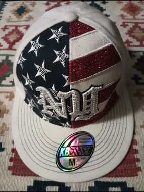 The KBETHOS USA cap features an American flag design with glitter details. SZ M